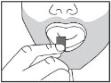 A person holding a small piece of candy
Description automatically generated
